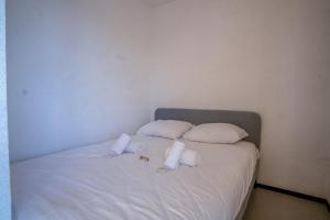 uma cama com almofadas brancas e toalhas em Flat with a view in Huez - Welkeys em LʼHuez