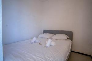 a bed with white pillows and towels on it at Appartement Aldeïa - Welkeys in LʼHuez