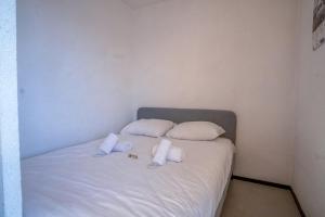 a white bed with two pillows on it at Appartement Aldeïa - Welkeys in LʼHuez