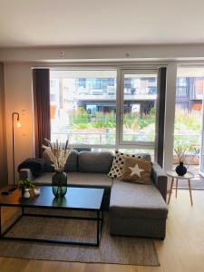 a living room with a couch and a large window at Leilighet ved Tønsberg Brygge in Tønsberg