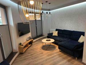 un soggiorno con divano blu e tavolo di Beautiful Apartment Tarasy Wiślane Free GARAGE a Cracovia