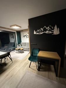 una sala de estar con una silla verde y una mesa en Narciarska6A Apartamenty en Szczyrk