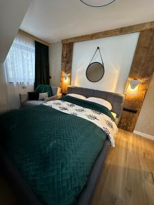 1 dormitorio con 1 cama verde y 1 sofá en Narciarska6A Apartamenty en Szczyrk