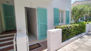 ein Haus mit grünen Rollläden an der Seite in der Unterkunft Appartamento cod. 456 Taunus Vacanze in Marcelli