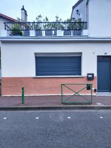 a building with a gate on the side of a street at PARIS de FLORE Flore in Malakoff