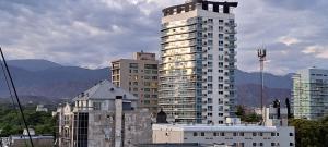 un edificio blanco alto frente a algunos edificios en Aconcagua VI en Mendoza