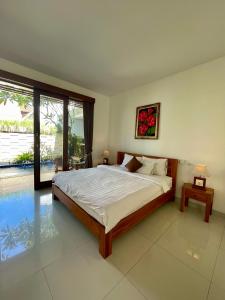 sypialnia z dużym łóżkiem i basenem w obiekcie Bali Ayu Pool Villa w mieście Canggu