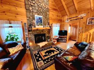 ein Wohnzimmer mit einem Steinkamin in einer Hütte in der Unterkunft Little Wolf Cabin in Maggie Valley