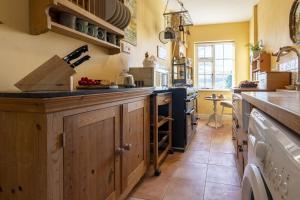 - une cuisine avec des placards en bois et un comptoir dans l'établissement Acorn Cottage, à Bolton Bridge