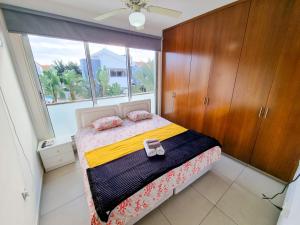 1 dormitorio con cama y ventana grande en Beach Villa With Private Pool And BBQ en Lárnaca
