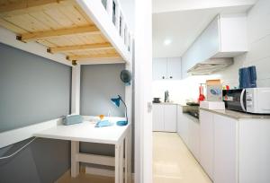 a small kitchen with white cabinets and a white table at Student Accommodation - 292 Hennessy Road in Hong Kong