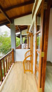 a wooden chair sitting on the porch of a house at The Point Mirissa in Mirissa