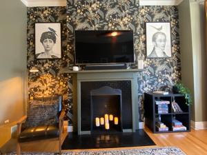 a living room with a fireplace with a flat screen tv at Elegant Hideaway in the Heart of Andersonville in Chicago