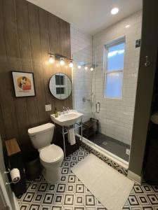 y baño con aseo, lavabo y ducha. en Elegant Hideaway in the Heart of Andersonville, en Chicago