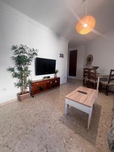 a living room with a flat screen tv and a table at Apartamento El Faro in Barbate