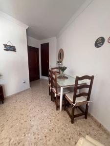 Apartamento El Faro في بارباتي: غرفة طعام مع طاولة وكراسي