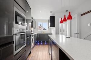 a kitchen with stainless steel appliances and red pendant lights at Superb Stonewall Terrace in London