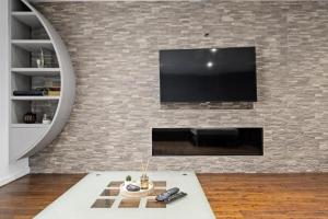 a living room with a tv on a brick wall at Superb Stonewall Terrace in London