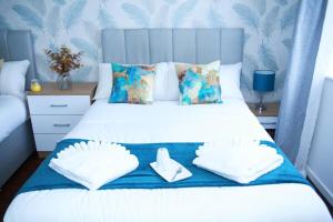 a bedroom with a bed with white sheets and blue wallpaper at Superb Stonewall Terrace in London