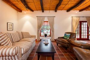 a living room with a couch and a table at Nabygelegen Gate house in Bainʼs Kloof