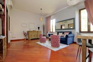 a living room with a blue couch and pink chairs at Beautiful apartment with amazing Rooftop&Jacuzzi in Rome