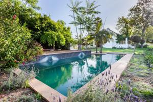 a swimming pool in a yard with trees and a house at Nabygelegen Gate house in Bainʼs Kloof