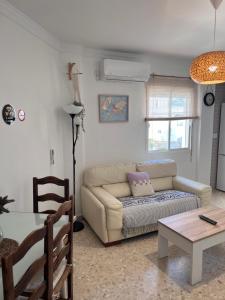 Apartamento El Faro في بارباتي: غرفة معيشة مع أريكة وطاولة