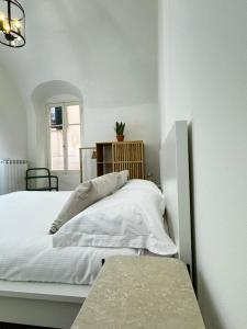 ein weißes Schlafzimmer mit einem Bett und einem Tisch in der Unterkunft BordiLand 1 in Bordighera