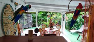 2 perroquets perchés sur une table dans un restaurant dans l'établissement La kaz créole, à Bouillante