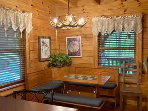 ein Esszimmer mit einem Tisch, Stühlen und einem Kronleuchter in der Unterkunft Little Wolf Cabin in Maggie Valley