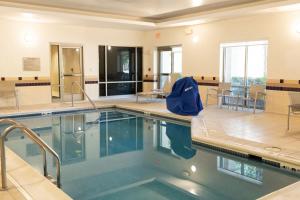 una piscina en una habitación con mesas y sillas en SpringHill Suites Norfolk Old Dominion University, en Norfolk