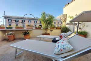 two picnic tables on a balcony with a building at Beautiful apartment with amazing Rooftop&Jacuzzi in Rome