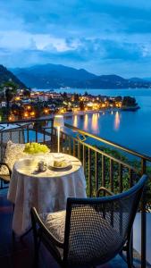 una mesa y sillas en un balcón con vistas al agua en Hotel La Rondinella, en Cannero Riviera