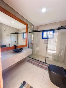 a bathroom with a glass shower and a sink at Hotel Pontal de Tiradentes in Tiradentes