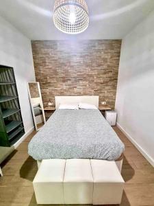 - une chambre avec un lit et un mur en briques dans l'établissement Puerto Amazonas apartamento con jacuzzi privado, à El Puerto de Santa María