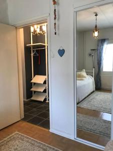 Habitación con dormitorio con cama y espejo. en Romanttinen Retrokaksio, en Oulu