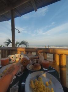 a table with a plate of food on the beach at Bungalows Sol y Mar in Canoas De Punta Sal