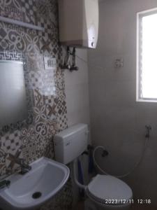 Royale Seaward Comfort Suites في تشيناي: حمام به مرحاض أبيض ومغسلة