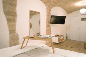un miroir sur un mur dans une pièce avec une table dans l'établissement Mary House, à Bari 14 autres photos