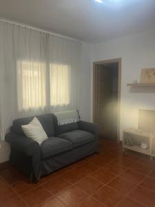 ein Wohnzimmer mit einem Sofa und einem Fenster in der Unterkunft El Isleño in Valverde