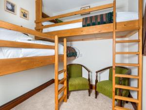 a bedroom with bunk beds with a ladder and two chairs at 3 Bed in Eskdale SZ502 in Eskdale