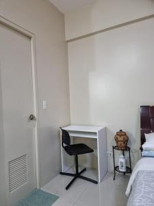 Schlafzimmer mit einem Schreibtisch, einem Bett, einem Schreibtisch und einem Stuhl in der Unterkunft One Palm Tree Villas Condo Across NAIA Terminal 3 in Manila