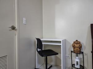 - un bureau avec une chaise à côté d'une table blanche dans l'établissement One Palm Tree Villas Condo Across NAIA Terminal 3, à Manille