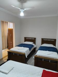 een slaapkamer met 2 bedden en een plafondventilator bij Sevili Garden Hotel in Arujá