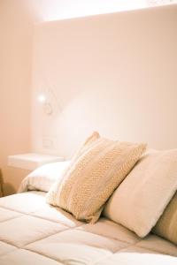 un lit blanc avec deux oreillers dessus dans l'établissement Mary House, à Bari