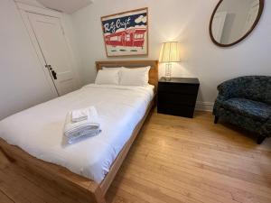 a bedroom with a bed with a mirror and a chair at Logan Square Hideaway in Chicago