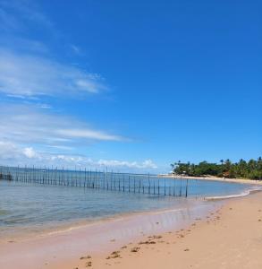 a beach with a pier in the water at Casa em Barra Grande com piscina in Marau