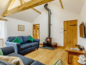 ein Wohnzimmer mit einem Sofa und einem Holzofen in der Unterkunft 2 Bed in Taunton 80694 in North Curry