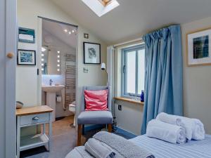 ein Schlafzimmer mit einem Bett, einem Stuhl und einem Waschbecken in der Unterkunft 1 Bed in Hay-on-Wye 81312 in Talgarth