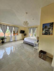 a large bedroom with a bed and a chandelier at Villa sol de samana' in Los Róbalos